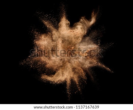 Explosion of brown powder on black background. Royalty-Free Stock Photo #1137167639