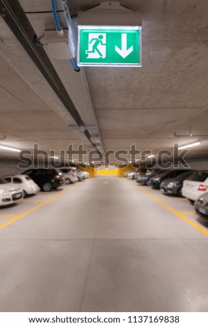 Green emergency exit sign on white in the parking car.  image for background, copy space, objects, illustration and article