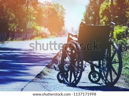 close up of wheel chair on the country road with highlight and shadow can be used for medical or health background, Hope concept