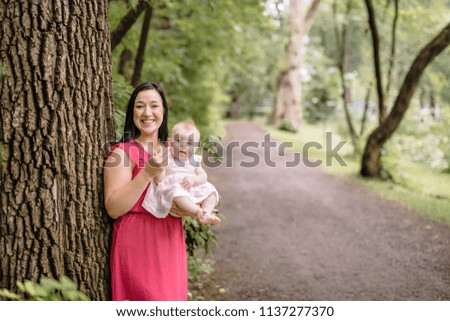 Mother and daughter baby in summer meadow park