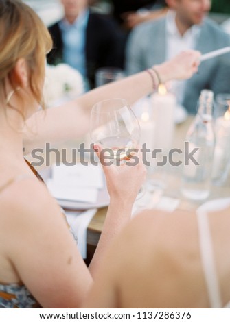 Woman Cheers with a Glass of White Wine