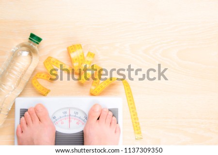 Lifestyle concept: proper nutrition, weight loss, scales, clear water, dietary supplements, measuring tape, clearing the body of toxins. Dietetic food that nutritionists advise for a athletes health.