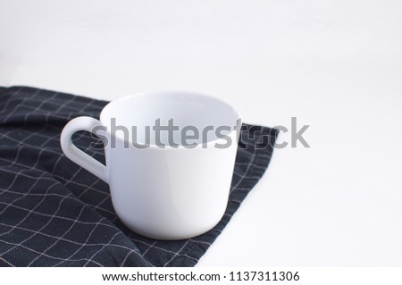 Morning coffe Breakfast White porcelain cup and checkered black napkin Minimal Picture White Background Kitchen Supplement Copy Space Preparation Kitchen Table