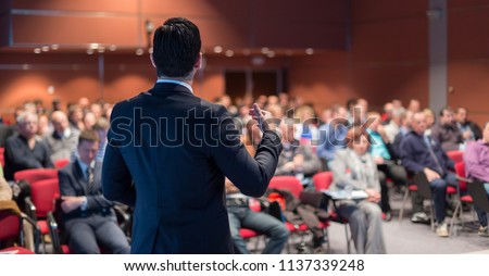 Speaker giving a talk on corporate business conference. Unrecognizable people in audience at conference hall. Business and Entrepreneurship event. Royalty-Free Stock Photo #1137339248