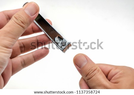 Male's hand holding on nail clippers,Man use nail clipper cutting their thumbs nail Royalty-Free Stock Photo #1137358724