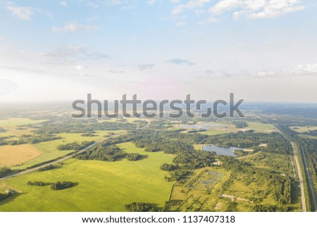 Helicopter drone shot. Aerial photography of green forest  with lake and  road, green grass.