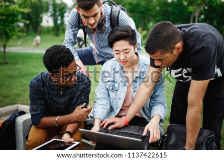 A group of students from different countries are discussing a new project. Students live and study on campus. The photo illustrates education, College, school, or University.