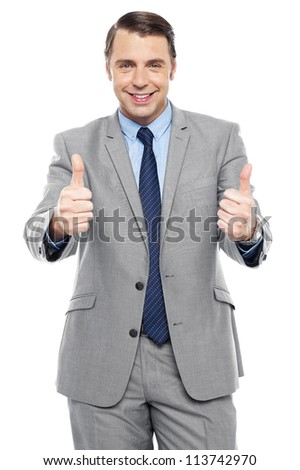 Handsome executive showing double thumbs up to camera. Dressed in business suit