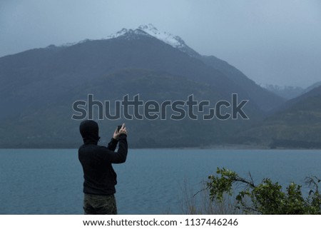 Man Taking Picture of Lake Wanaka in New Zealand