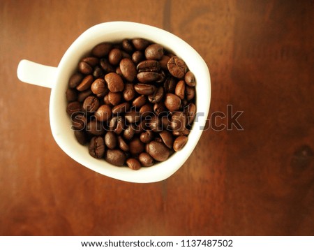 close up, roasted coffee bean on white cup