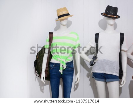 Two mannequin in female shirt with blue ,shorts jeans,sunglasses, handbag,hat, 

