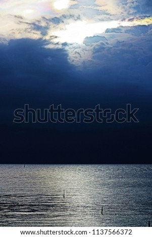 scenery seascape with reflection on sea surface by sunlight when sun setting behind cloud over horizon in the evening on cloudy day so impressive outdoor pattern for beautiful nature background