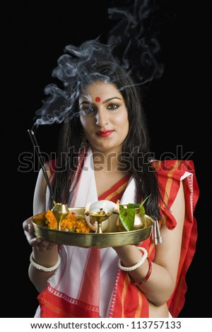 Beautiful woman in a Bengali sari holding pooja thali