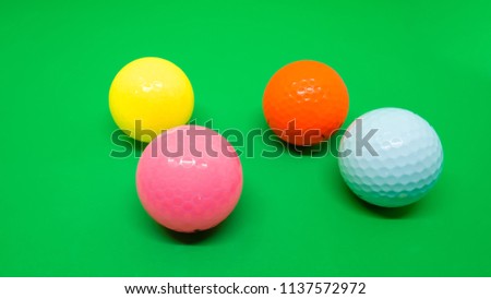 Colored golf ball on green background