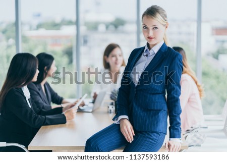smart and relax beautiful caucasian manager woman in blue suit standing in meeting conference room