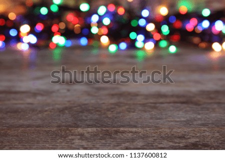 Wooden table and blurred Christmas lights on background