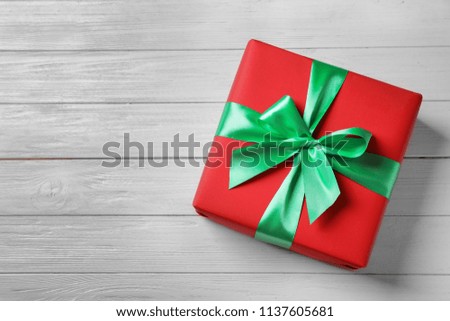 Beautiful gift box on wooden background, top view