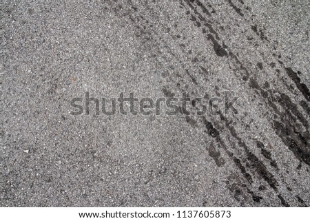 asphalt road texture with dark tire tracks on gray asphalt road
