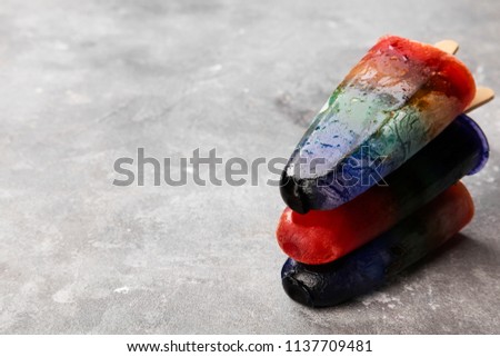 Rainbow colorful ice cream popsicle pile with wood stick on gray background. Cope space. Food background