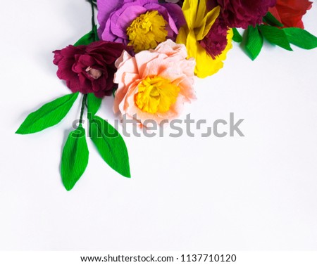 Colorful handmade flowers on a white background with copy space. Crepe paper. Master Class. St. Valentine's Day and Mother's Day. Decor for the holiday.