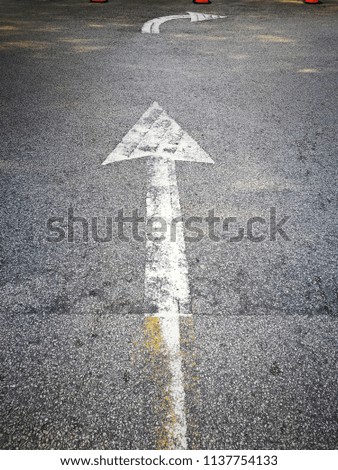Arrow sign on bitumen road
