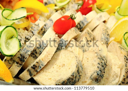 Stuffed sliced pike, decorated with tomato, lemon and cucumber close up in restaurant