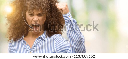 African american call center operator woman annoyed and frustrated shouting with anger, crazy and yelling with raised hand, anger concept