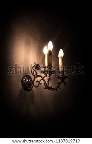 Old electric lamp on a limed wall with dark background