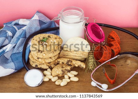 homemade white and black chocolate cookies on wood table with chips,milk and peanuts and weight loss concept