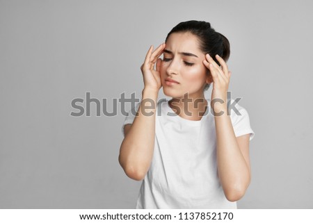 woman with eyes closed holds the head of a migraine                               