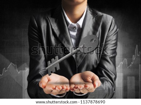 Cropped image of businessman in suit keeping stone key symbol in hands with business sketches on dark wall on background. 3D rendering.