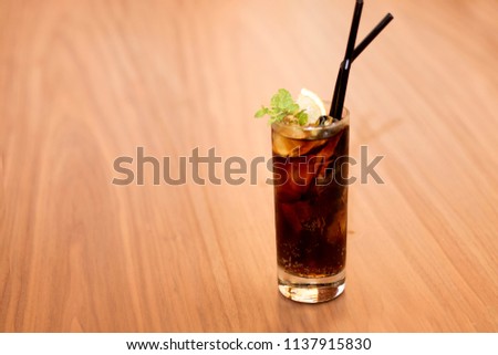 Malibu Cola Cocktail with mint on Wodden Table