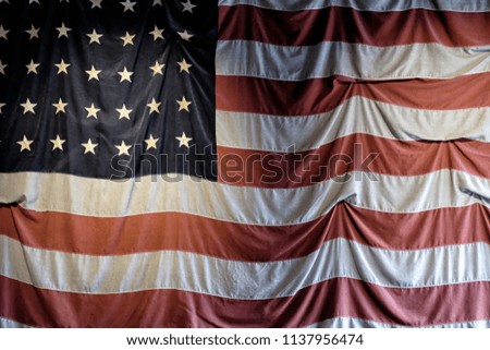 Close up of the US flag hanged on a wall, grunge feel, great as a background 