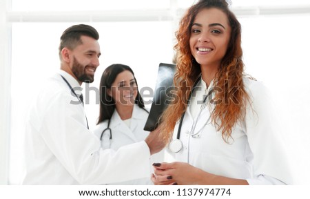 confident doctors in hospital looking at x-ray.