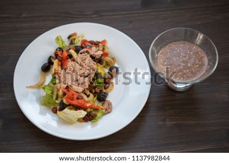 photo of a real meal on a dark background on a white plate. Food is right in front of the camera with cutlery