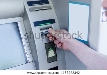 Man hand puts card, press button gray ATM. Technology of business. Banking system. Inflation.