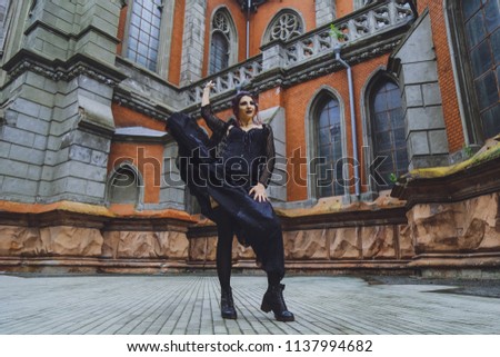 Young brunette girl in gothic style on a background architecture
