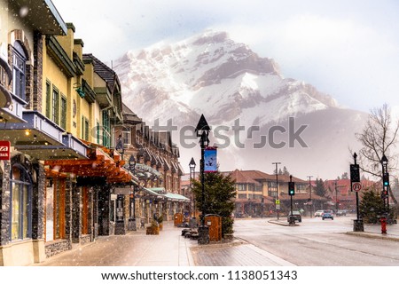 View of a busy street at Banff city Canada during transition season from winter to snow Royalty-Free Stock Photo #1138051343
