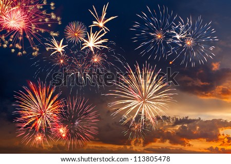 Beautiful colorful holiday fireworks in the evening sky with majestic clouds,  long exposure Royalty-Free Stock Photo #113805478