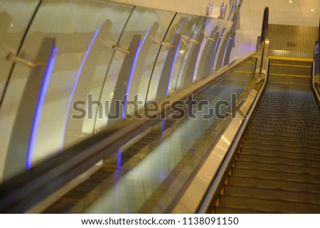 blurred photo of escalator in department store and a woman stand alone