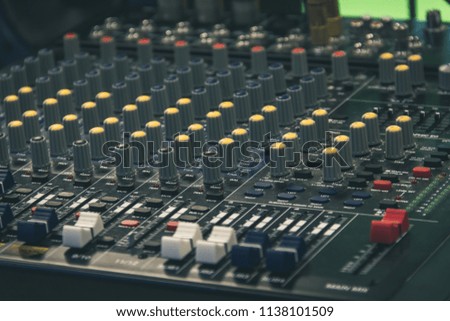Television set professional audio mixer. Mixing desk, sound board. Blue, yellow and red controls and equalizers. Film and music studio recording equipment. Vintage effect