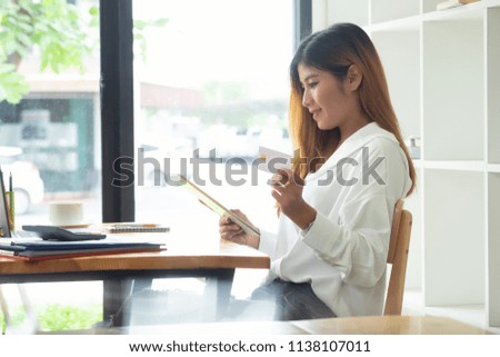 Woman using credit card and digital tablet shopping online in office work table.