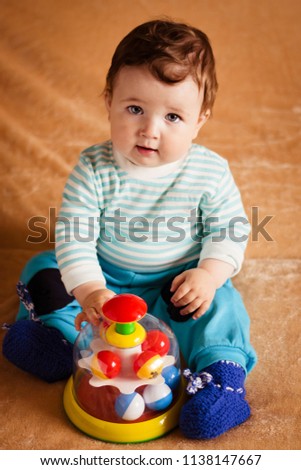 beautiful little baby with blue eyes playing with Yule toy