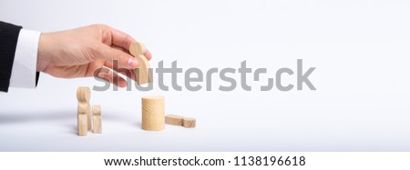 A man's hand of a businessman in a business suit holds a wooden figure of a man in his hand and moves another figure from his post. The concept of firing an employee, the replacement of staff. Banner