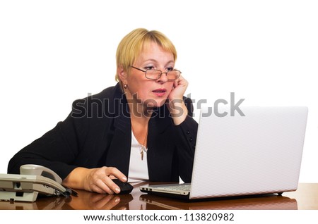Mature businesswoman working with laptop on her workplace. Isolated against white background.
