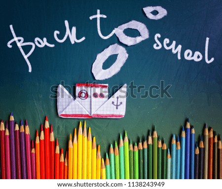  steamer of paper on the background of board with chalk drawings / inscription 'back to school'/school background
