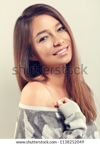 Happy casual toothy natural smiling woman in grey warm sweater looking on empty copy space background. Closeup toned vintage portrait