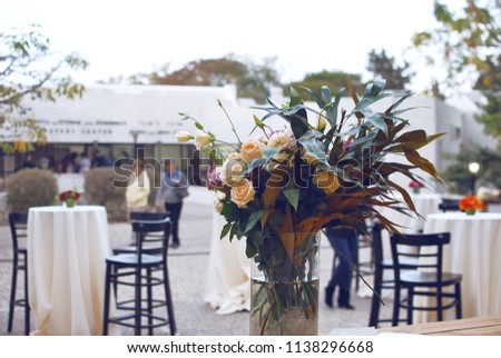a bouquet of flowers on the table. wedding party. high bar stools around round tables Royalty-Free Stock Photo #1138296668