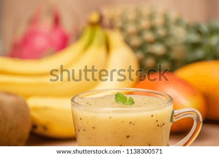 Tropical fresh fruit set and juice smoothies isolated with wooden background

