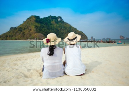 back view of  two Asian women on the beach Similan Islands Thailand